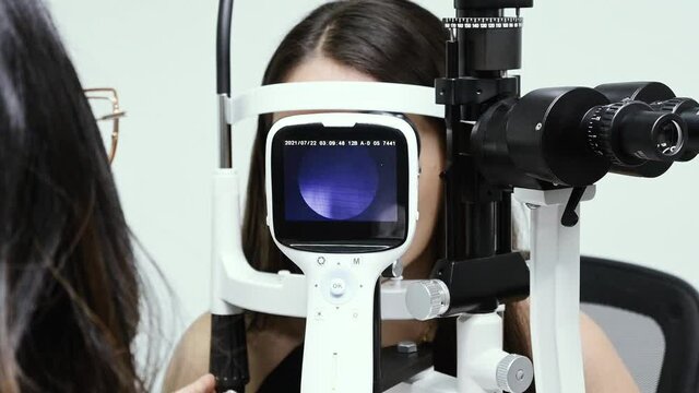 Doctora de la salud visual haciendo un examen de la vista con una maquina para fondo de ojo