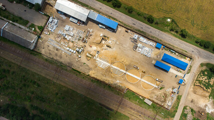 Aerial view of modern grain elevator. Wheat storage building, building in progress. Silo farm. Agribusiness development construction.