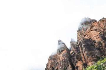 The mountains of Zion National Park in Utah with a heavy overcast and clouds dramatically passing in from of the peaks.