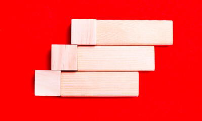 On a bright red background, light wooden blocks and cubes with a place to insert text.