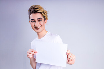 happy asian man with luxurious blonde hair and gorgeous make-up holding mock up board in white wall studio background