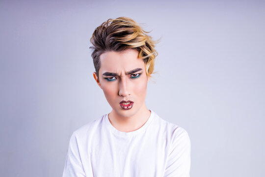 confused wonder asian man with luxurious blonde hair and gorgeous make-up in white wall studio background