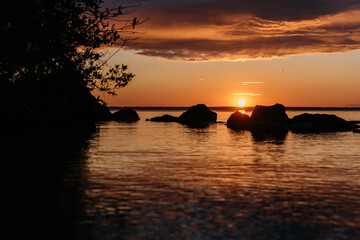 Photo of a Summer Sunset on the Lake. Travel location of popular tourist outdoor. View of beautiful Sea Landscape. Relax vacation near water
