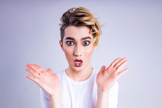 Oops, what did I do asian man with luxurious blonde hair and gorgeous make-up in white wall studio background