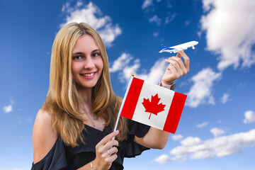 Girl holds flag of Canada and toy plane on the sky background Concept of air travel and tourism 