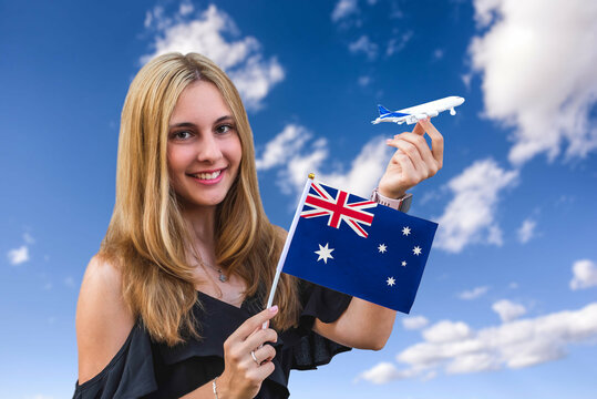 Girl Holds Flag Of Australia And Toy Plane On The Sky Background Concept Of Air Travel And Tourism 