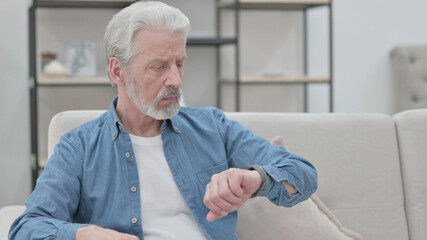 Old Man Checking Watch While Waiting on Sofa 