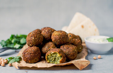 Fresh falafel balls on a black gray background with yoghurt sauce. Vegetarian food