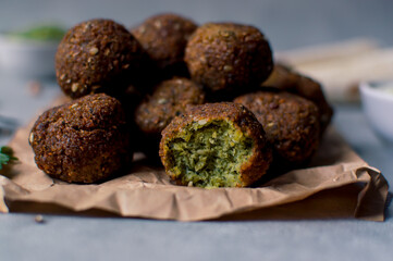 Fresh falafel balls on a black gray background with yoghurt sauce. Vegetarian food