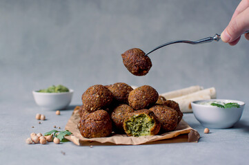 Fresh falafel balls on a black gray background with yoghurt sauce. Vegetarian food