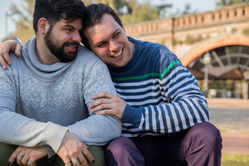 Happy gay couple sharing a romantic embrace outdoors.