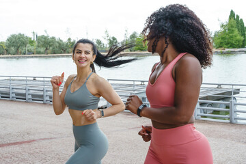 Fitness women running together. Feminist women training in sportswear of different nationality.