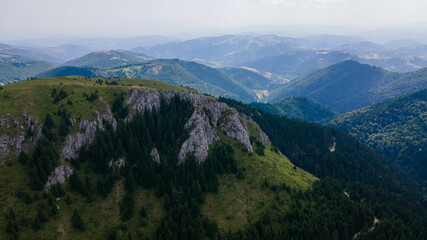 Aerial view of mountains covered with coniferous forests. Aerial beautiful dramatic cloudy sky with mountain view during sunset, Kopaonik, Serbia.