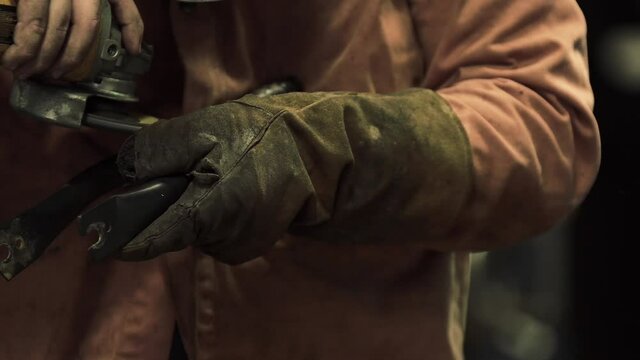 c&aacute;mara lenta de un hombre con un esmeril en sus manos con guantes