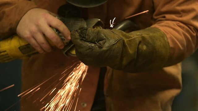 c&aacute;mara lenta de un hombre con un esmeril en sus manos con guantes