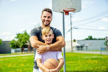 Happy basketball family portrait play this sport on summer season. The father play with boy