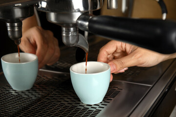 Barista making espresso using professional coffee machine, closeup