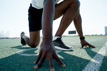 Photo below. African American athlete man preparing for the race at the competition standing at the...