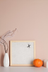felt letter board with space for text with candle, pumpkin and branches on beige background