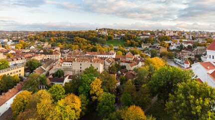 Fototapeta na wymiar Beautiful Vilnius city panorama in autumn with orange and yellow foliage. Aerial evening view. Fall city scenery in Lithuania