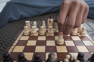 hand of businessman moving chess figure in competition success play