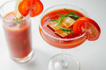 Bloody Mary cocktail prepared with pure vodka, tomato juice and hot pepper sauce, drink decorated with a slice of tomato