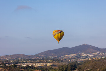Colorful yellow and red hot air balloons over blue sky in California