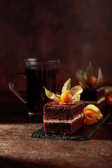 Chocolate cake with physalis on a brown background.