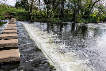 Obraz premium Concrete stepping stones across the Weir on the Skell River, Ripon, North Yorkshire, England.