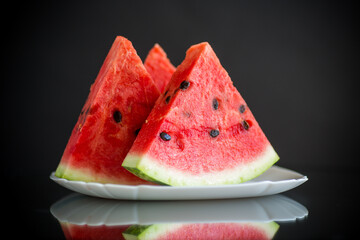pieces of fresh ripe red watermelon on black