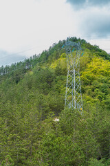 A huge supporting structure leading the overhead power line, standing almost at the very top of the mountain.