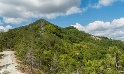 A huge supporting structure leading the overhead power line, standing almost at the very top of the mountain.
