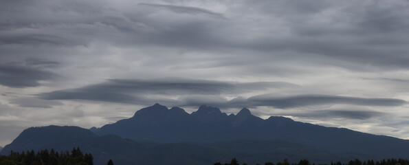 Golden Ears Mountain Peaks during dramatic cloudy sunset. Canadian Nature Landscape. Pitt Meadows, Vancouver, British Columbia, Canada. Nature Background Panorama