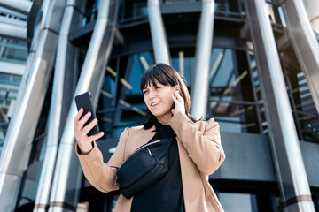 business woman using a phone and headphones