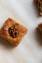 a piece of baklava cake with walnuts on baking paper. Vertical photo