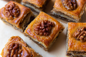 pieces of baklava with walnuts on baking paper with a central composition.