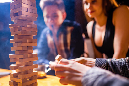 Young people have fun playing board games at a table .