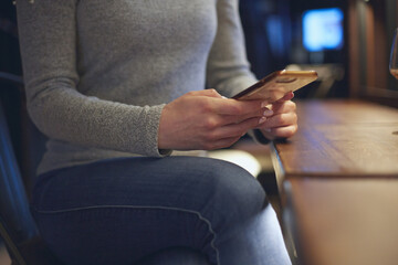 Obraz premium A woman sits at the table and drinks wine in a cafe. The concept of rest after a working day.
