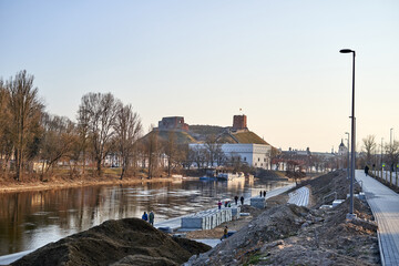 Fototapeta na wymiar Neris river and Gediminas castle in the background. The sides of the river are under repair. 
