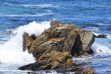 Ocean waves splashing onto some rocks at 17 Mile Drive in Monterey, California.