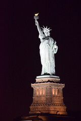 statue of liberty on pedestal at night with black background