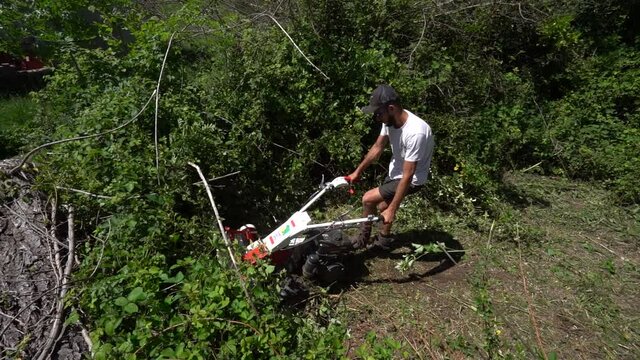 Man Uses Flail Mower To remove Unwanted Heavier Grass - Scrub