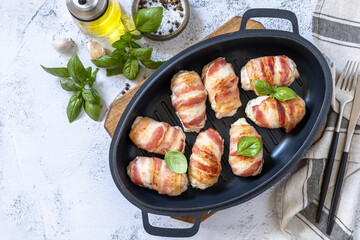 A festive dish. Baked chicken fillet with ricotta in bacon on a stone table top. Top view flat lay background. Copy space.