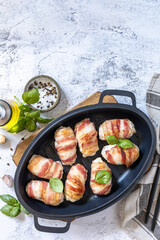 A festive dish. Baked chicken fillet with ricotta in bacon on a stone table top. Top view flat lay background. Copy space.