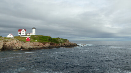 Fototapeta na wymiar New Castle, New Hampshire - July 5 2021: Portsmouth Harbor Lighthouse located on a rocky coast of Atlantic Ocean, guiding boats