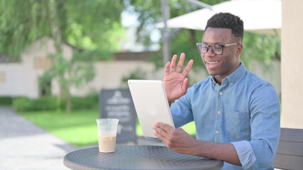 African Man making Video Call on Tablet in Outdoor Cafe