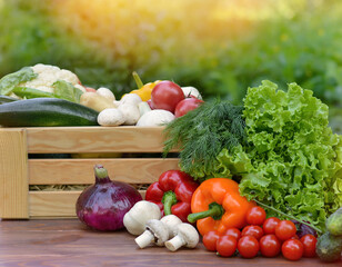Fresh organic vegetables in a wooden box and on a wooden table on the background of a vegetable...