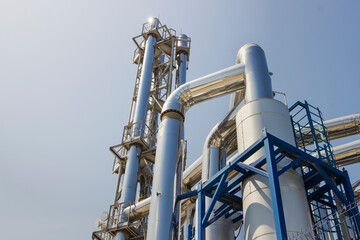 Process area of Petroleum plant with blue sky. Chimneys and silos of a factory.