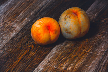 Peach fruit with leaf. Ripe juicy orange peach fruit of peach tree on wooden cutting rustic board. Peach harvest closeup in dark key.