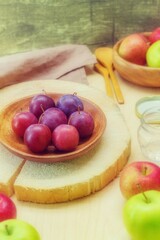 The vertical image shows a composition of rustic apples and plums